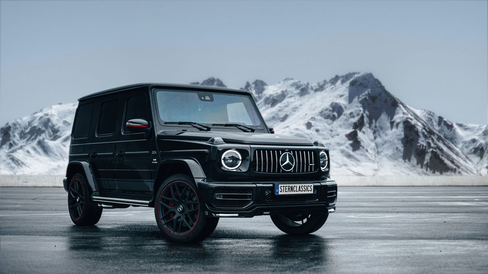 Mercedes-AMG Classe G nera sull’asfalto bagnato davanti a montagne innevate